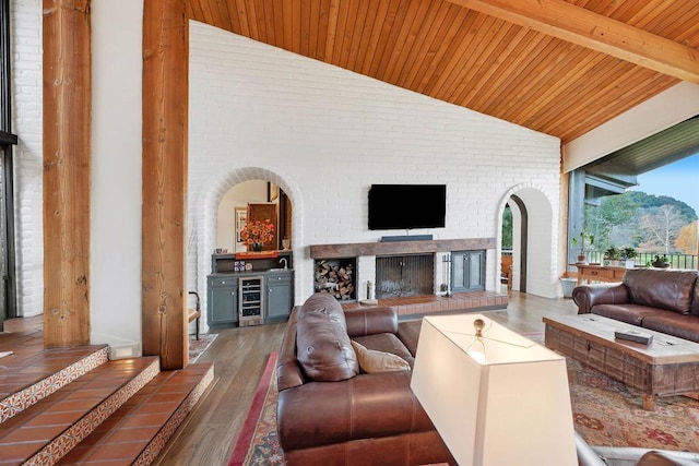 living room with a brick fireplace, wooden ceiling, dark hardwood / wood-style flooring, beamed ceiling, and beverage cooler