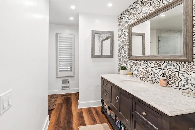 bathroom with vanity, wood-type flooring, heating unit, and backsplash