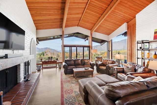 living room with brick wall, lofted ceiling with beams, wood ceiling, a mountain view, and a brick fireplace