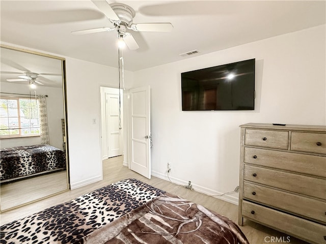 bedroom featuring ceiling fan, light wood-type flooring, and a closet