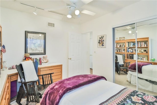 bedroom with light carpet, track lighting, and ceiling fan