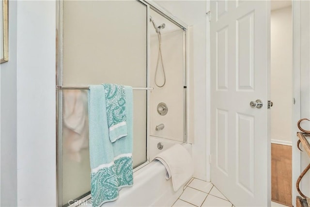 bathroom featuring tile patterned flooring and combined bath / shower with glass door