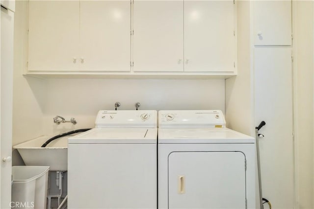 laundry room featuring cabinets and washer and clothes dryer