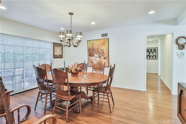 dining space featuring an inviting chandelier and wood-type flooring