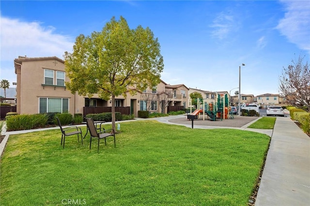 view of property's community with a playground and a lawn