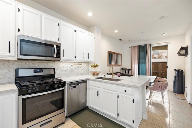 kitchen featuring white cabinetry, appliances with stainless steel finishes, sink, and kitchen peninsula