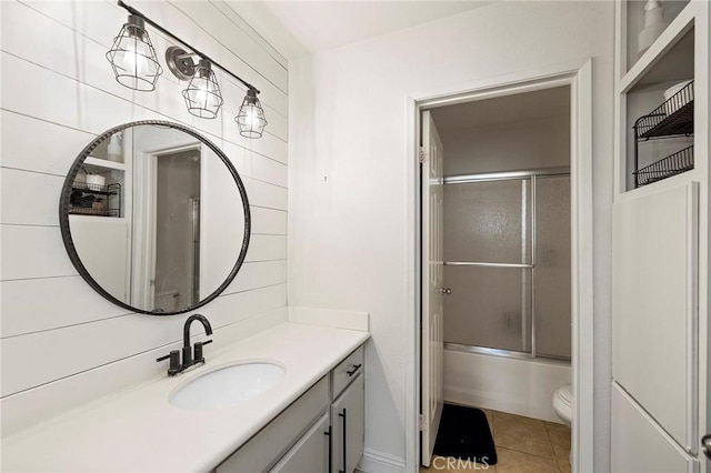 full bathroom with tile patterned floors, toilet, combined bath / shower with glass door, and vanity