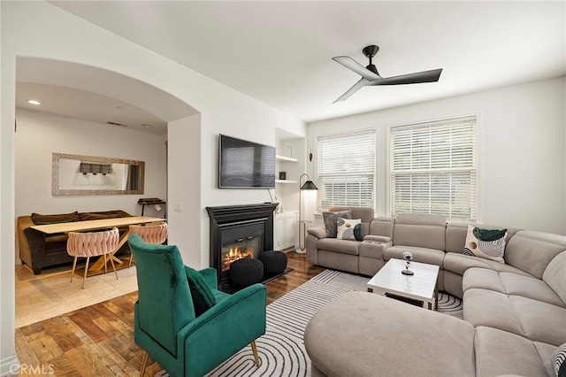 living room with ceiling fan and dark hardwood / wood-style flooring