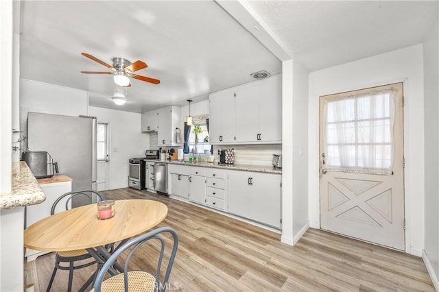 kitchen with sink, light wood-type flooring, ceiling fan, stainless steel appliances, and white cabinets