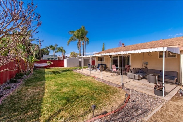 back of house featuring a storage shed, a yard, a patio area, and an outdoor hangout area