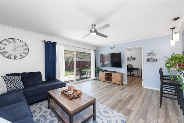 living room with ornamental molding, ceiling fan, and light hardwood / wood-style floors