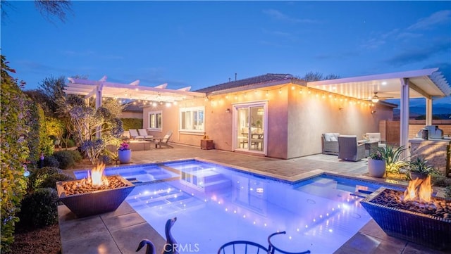 pool at dusk with an in ground hot tub, a pergola, a patio area, and a fire pit