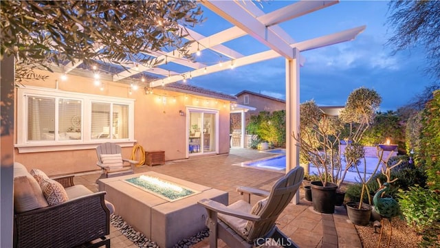 patio terrace at dusk with an outdoor fire pit and a pergola