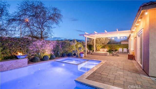 pool at dusk featuring a pergola, a fire pit, a patio area, and an in ground hot tub