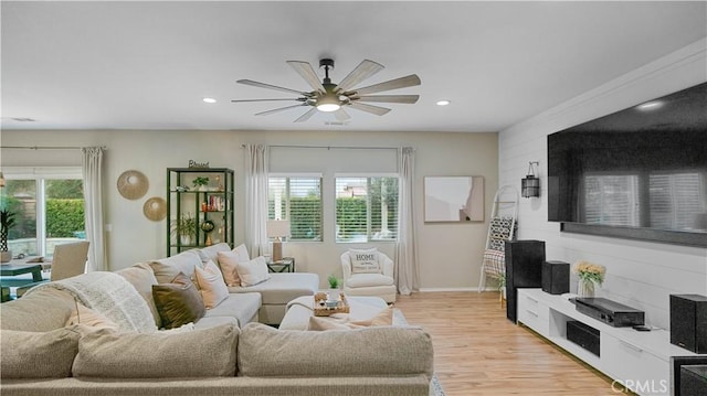 living room with light hardwood / wood-style flooring and ceiling fan