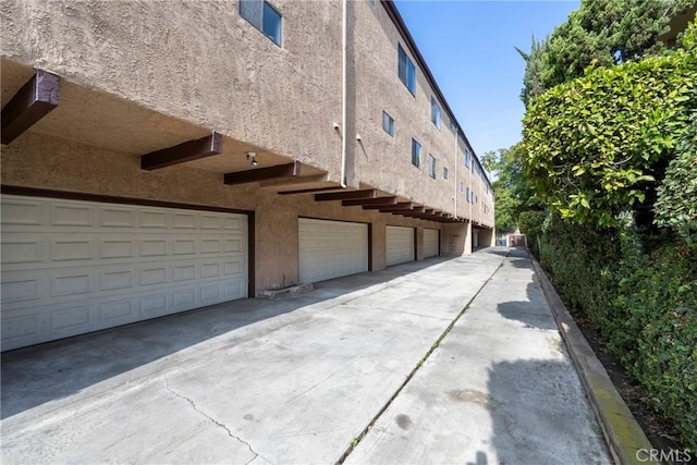 view of property exterior featuring an attached garage and stucco siding