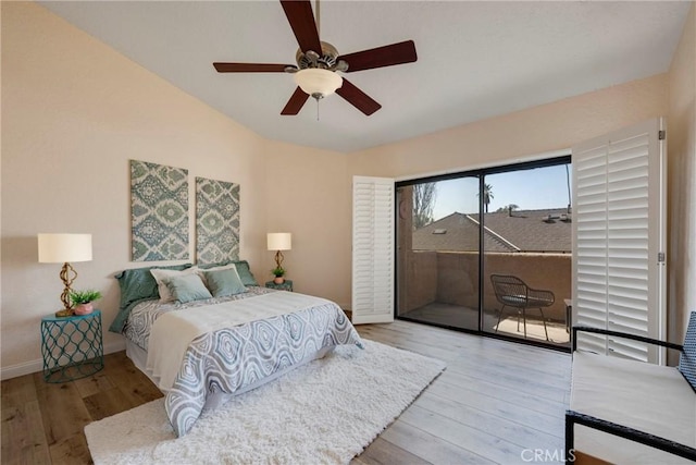 bedroom featuring a ceiling fan, access to outside, baseboards, and wood finished floors