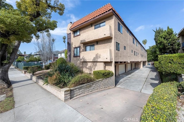 view of home's exterior with a tile roof and stucco siding