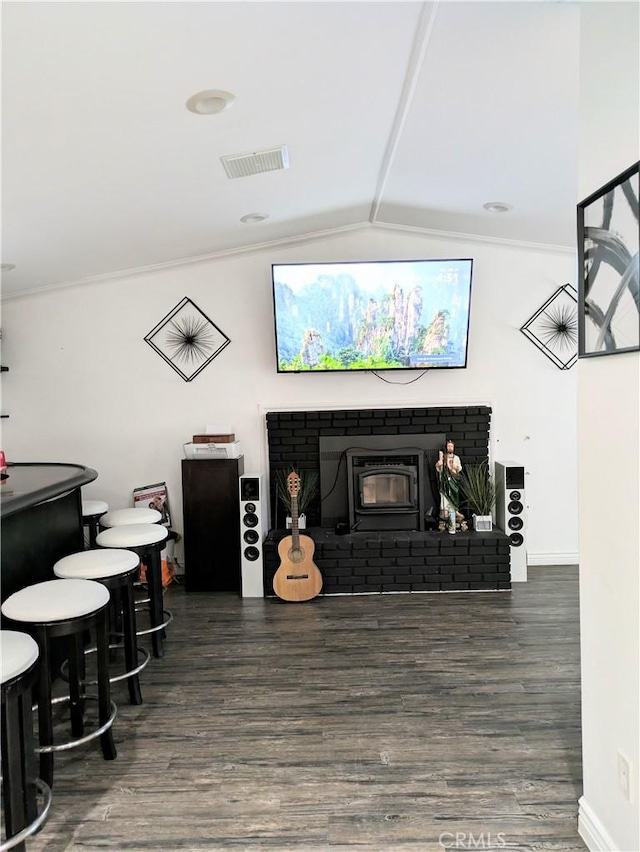 living room featuring dark hardwood / wood-style flooring, crown molding, vaulted ceiling, and bar area