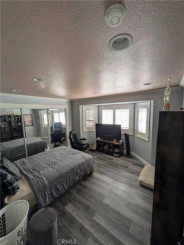 bedroom with wood-type flooring, a textured ceiling, and crown molding