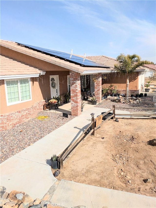 single story home featuring a patio area and solar panels