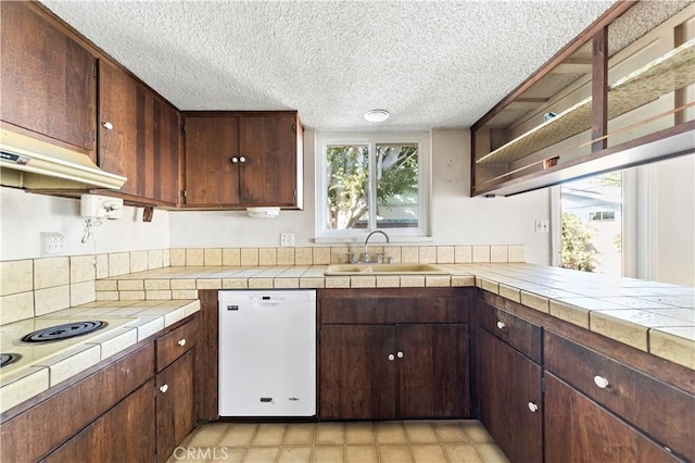 kitchen with tile countertops, sink, dark brown cabinetry, white dishwasher, and a textured ceiling