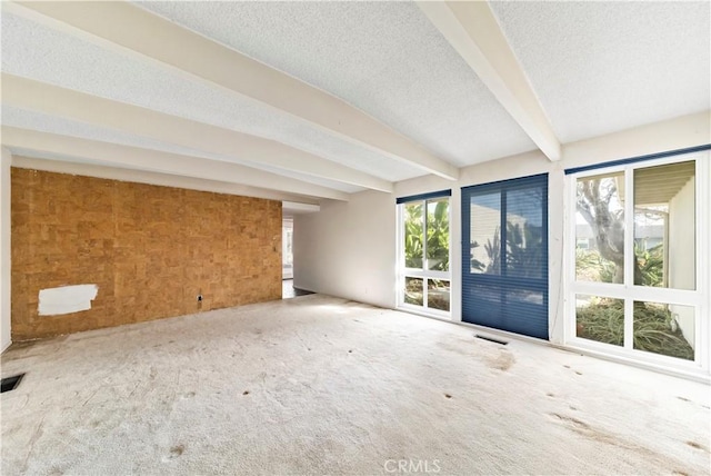 interior space with carpet flooring, beam ceiling, and a textured ceiling