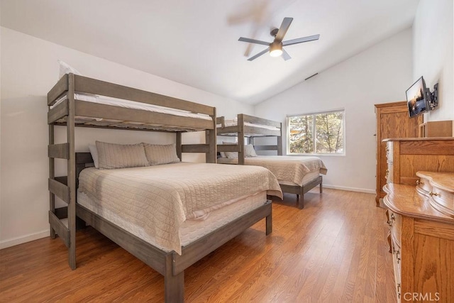 bedroom with hardwood / wood-style floors, high vaulted ceiling, and ceiling fan