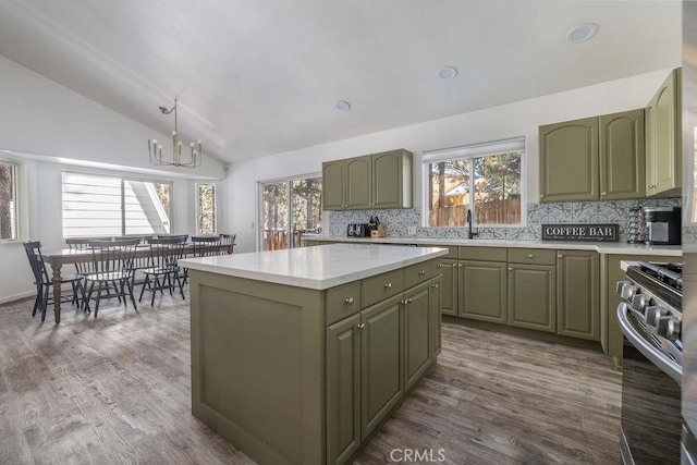 kitchen featuring tasteful backsplash, gas stove, lofted ceiling, and green cabinets