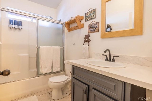 full bathroom featuring vanity, toilet, tile patterned flooring, and combined bath / shower with glass door