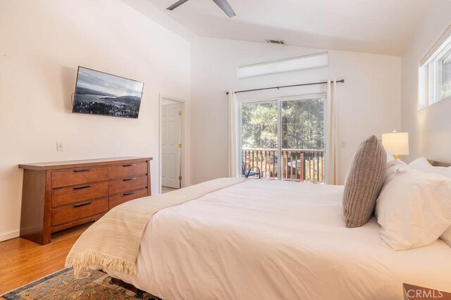 bedroom with multiple windows, lofted ceiling, access to exterior, and light hardwood / wood-style floors