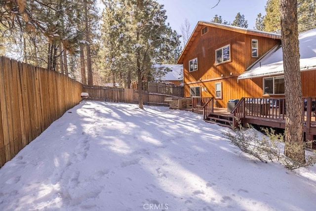 yard covered in snow with a deck