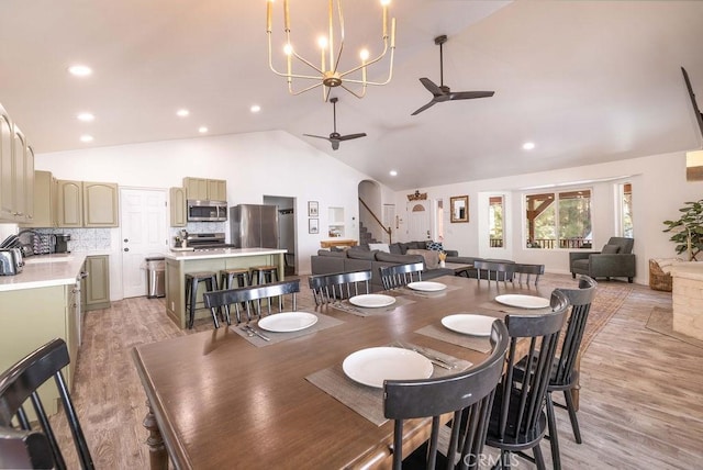 dining space with high vaulted ceiling, sink, ceiling fan, and light hardwood / wood-style flooring