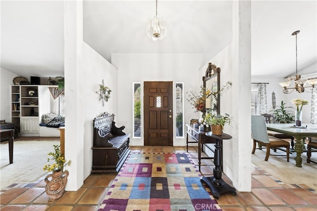 foyer with tile patterned floors, a healthy amount of sunlight, and a chandelier