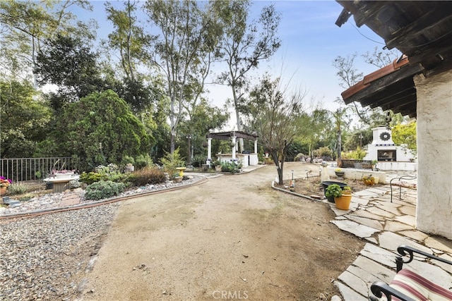 view of yard with exterior fireplace and a patio area