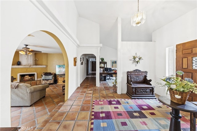 tiled foyer with a towering ceiling and ceiling fan