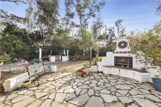 view of patio / terrace featuring exterior fireplace and a pergola