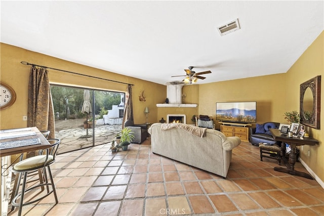 living room with a large fireplace and ceiling fan