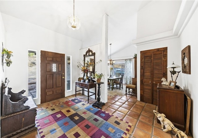 foyer with an inviting chandelier and high vaulted ceiling