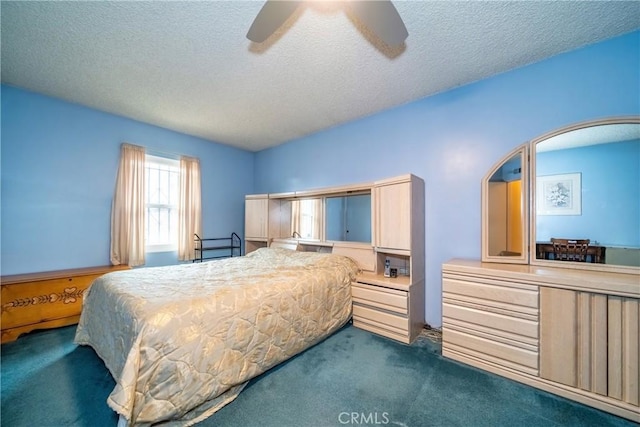 bedroom featuring ceiling fan, dark carpet, and a textured ceiling