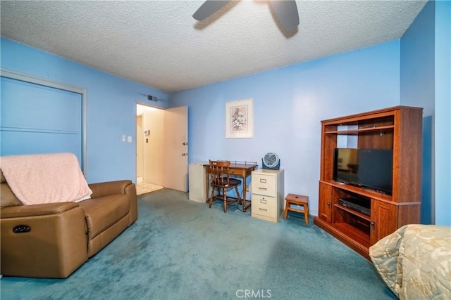 carpeted office space featuring ceiling fan and a textured ceiling