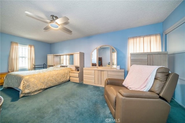 bedroom featuring ceiling fan, dark carpet, and a textured ceiling