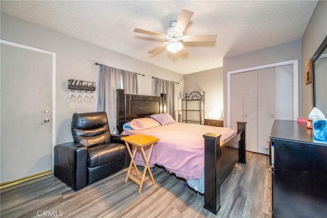 bedroom featuring ceiling fan, wood-type flooring, a closet, and a textured ceiling