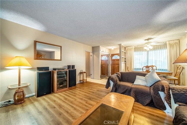 living room with ceiling fan, light hardwood / wood-style floors, and a textured ceiling