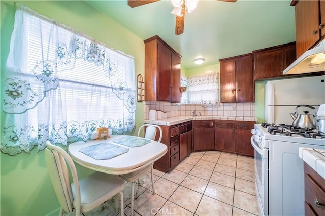 kitchen with backsplash, white appliances, ceiling fan, and light tile patterned floors