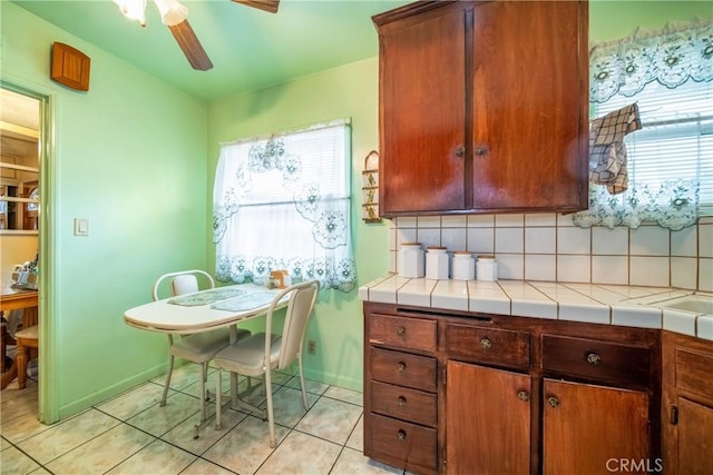 kitchen with plenty of natural light, tile countertops, backsplash, and light tile patterned floors