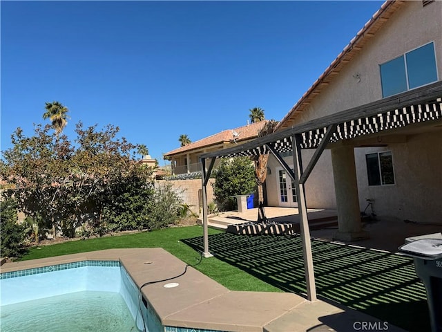 view of pool with a patio and a lawn