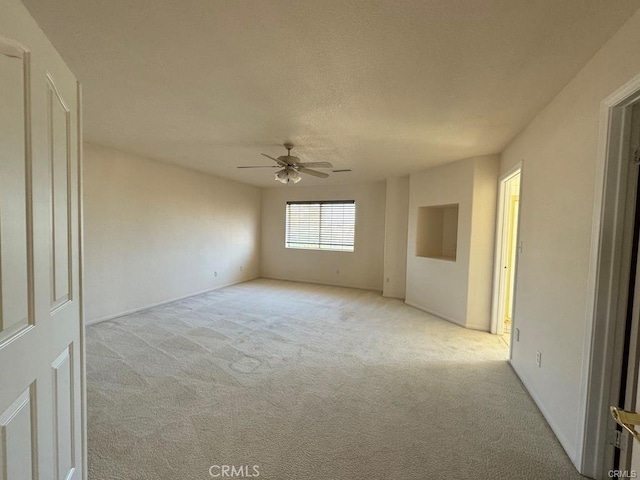 unfurnished room featuring light carpet and ceiling fan