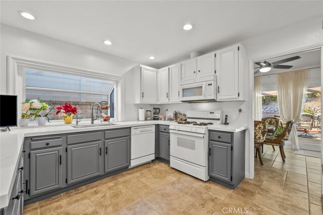 kitchen featuring sink, gray cabinetry, white cabinets, ceiling fan, and white appliances