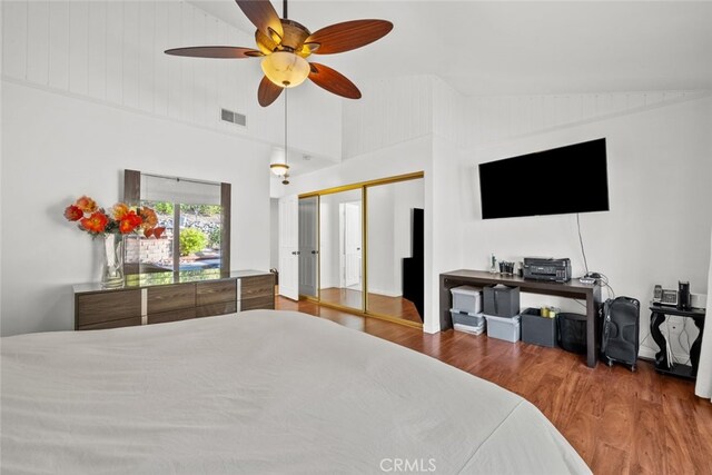 bedroom with ceiling fan, high vaulted ceiling, and hardwood / wood-style floors